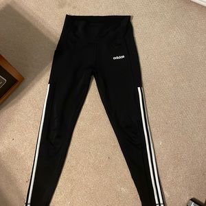 Black adidas leggings with white stripes. They are hight to mid rise